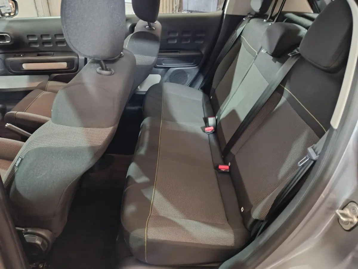 Vue intérieure côté droit montrant la banquette arrière grise avec ceintures et appuie-têtes du Citroën C3 2024.
