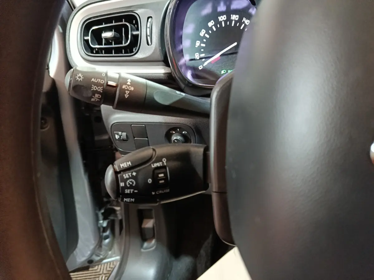 Gros plan sur la colonne de direction et le compteur, intérieur gris clair de la Citroën C3 BlueHDi 2024.