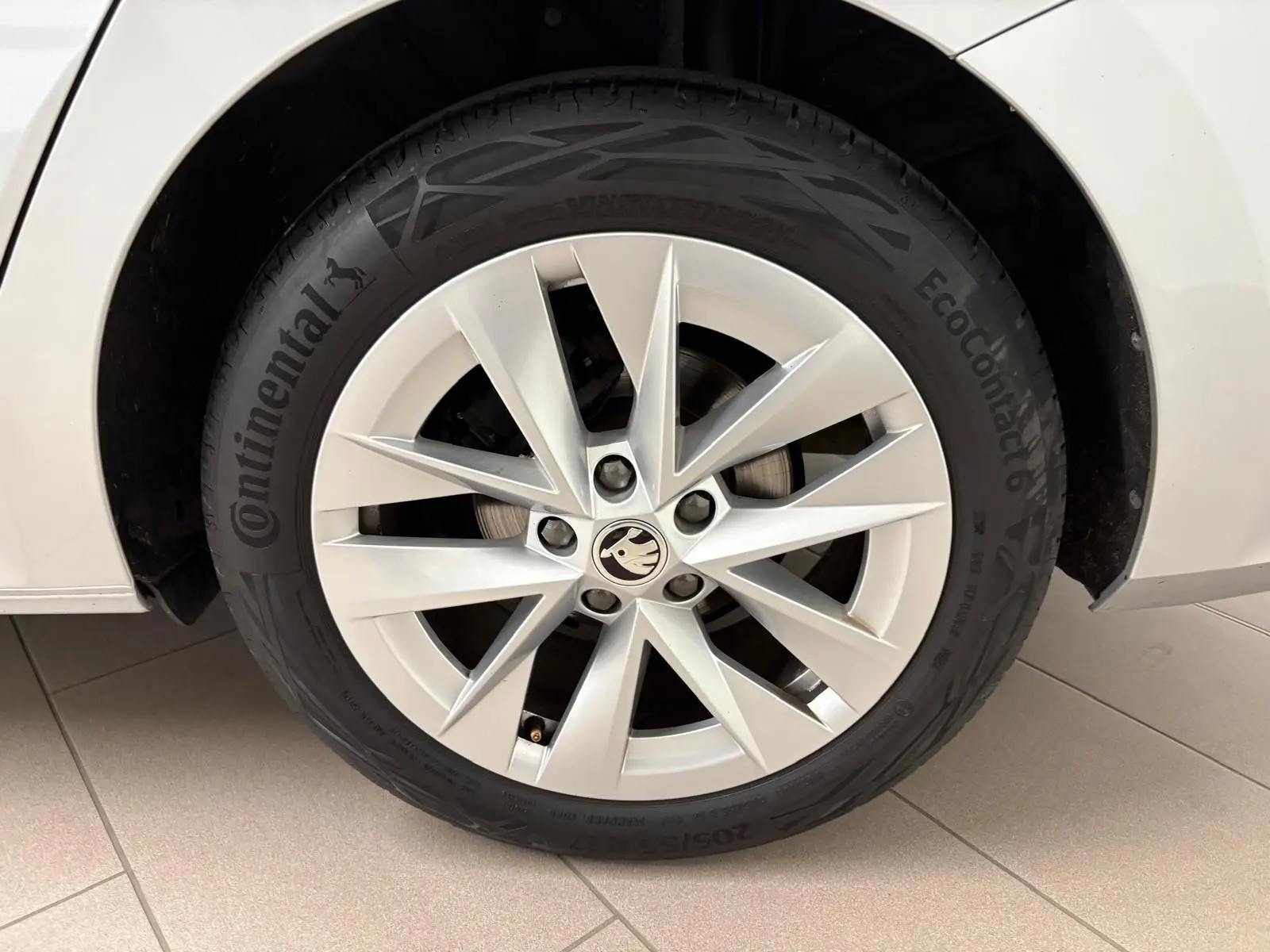 Gros plan sur la roue avant gauche d'une Skoda Octavia Combi gris argent 2023 avec jante alliage à dix branches.