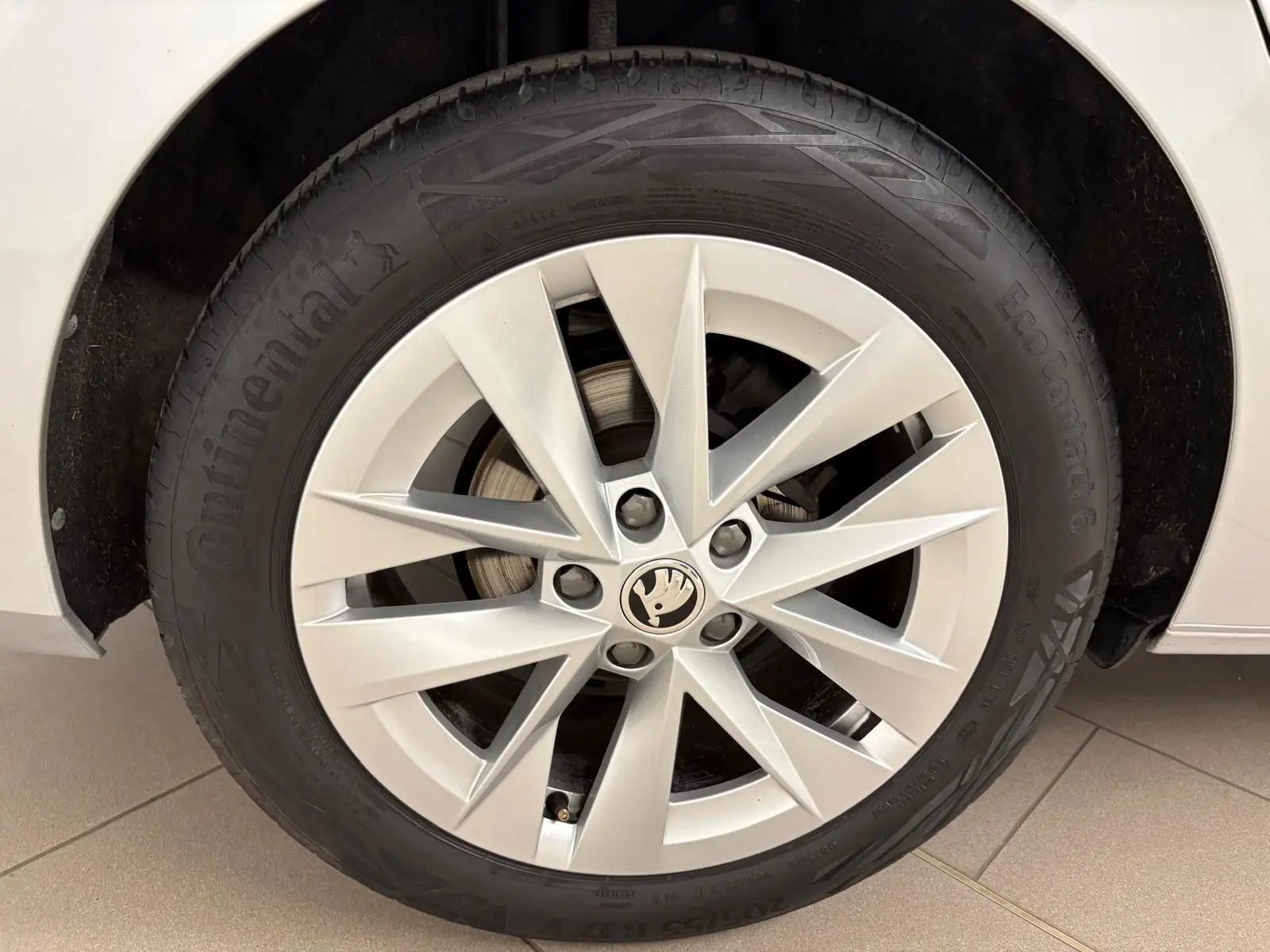 Gros plan sur la roue avant droite de la Skoda Octavia Combi gris argent avec jante alliage à dix branches.