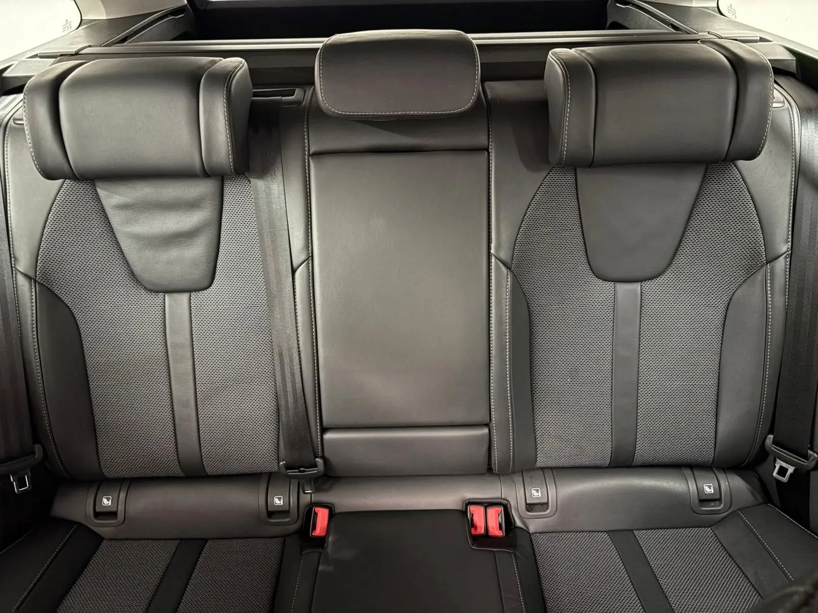 Vue rapprochée des sièges arrière en cuir noir et tissu gris de la Skoda Octavia Combi 2023.