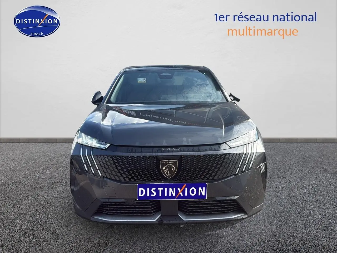 Vue frontale d'un Peugeot 3008 gris titane avec calandre noire et phares LED fins visibles.