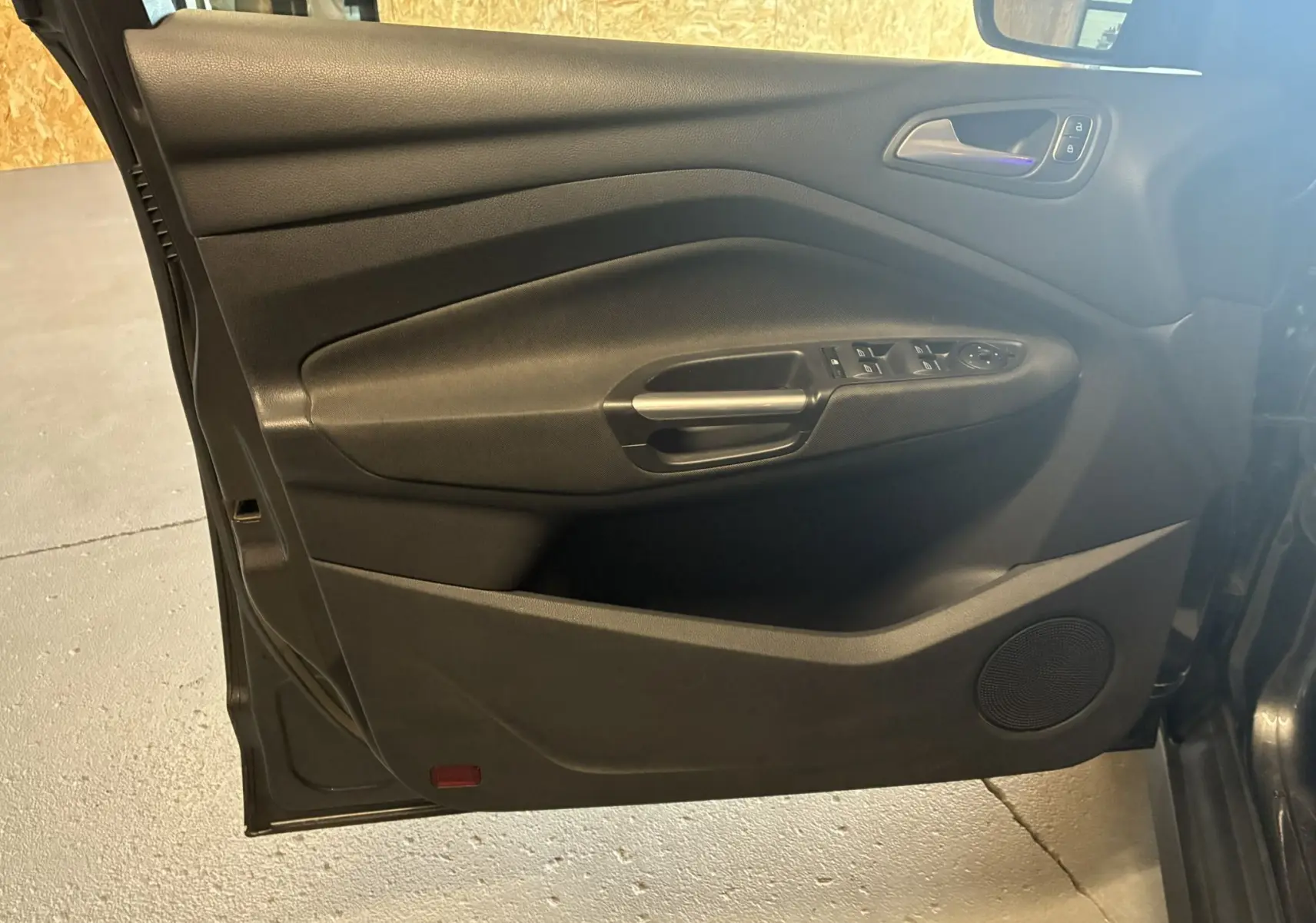 Porte avant gauche noire du Ford C-MAX 2015 avec commandes de vitres électriques et haut-parleur intégré.
