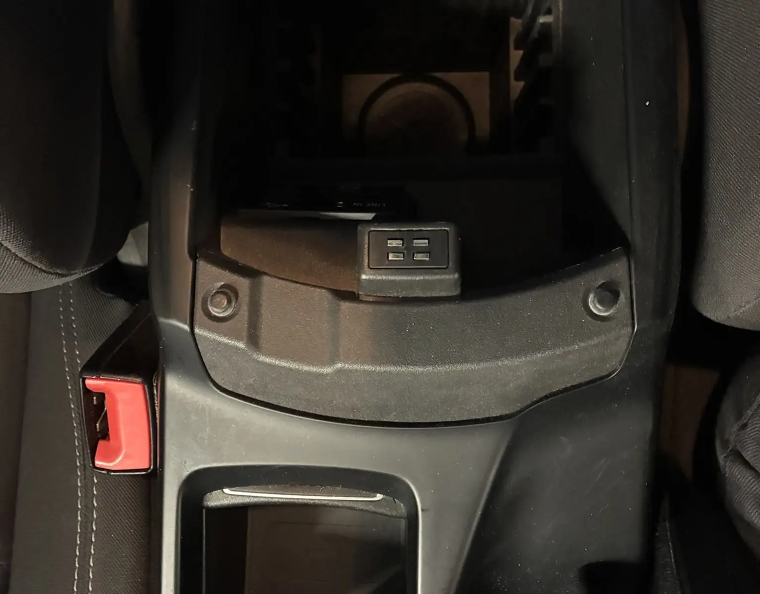 Vue plongeante sur la console centrale noire du Ford C-MAX gris 2015, avec porte-gobelets et bouton de commande visible.