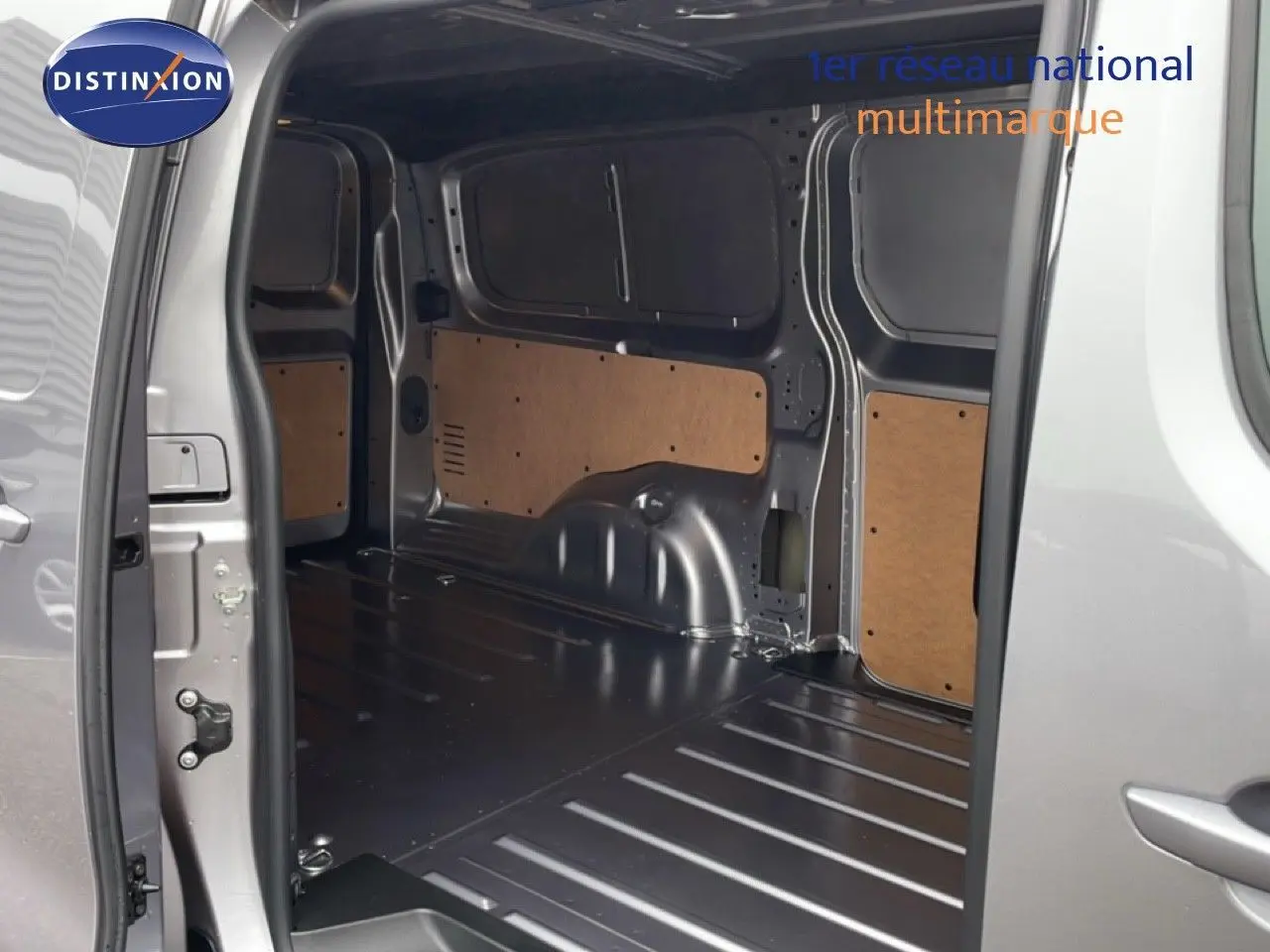 Vue intérieure du coffre ouvert côté droit d'un Citroën Jumpy gris Artense Métal avec parois en bois.