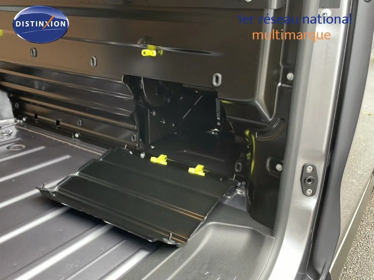 Vue intérieure du coffre côté droit du Citroën Jumpy gris Artense Metal avec compartiment ouvert et fixations jaunes visibles.