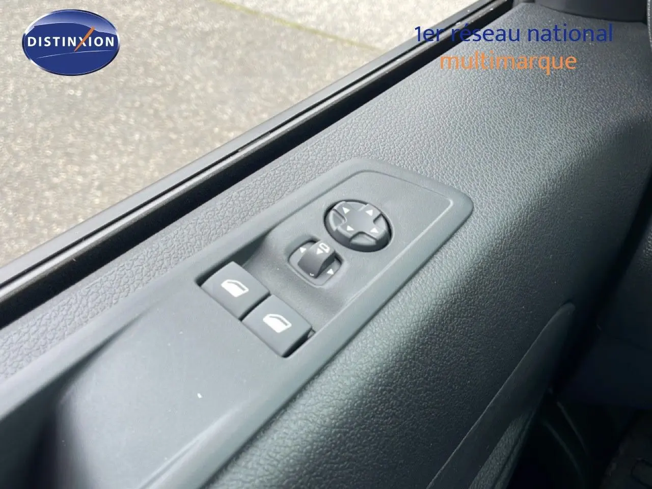 Gros plan sur les commandes des vitres et rétroviseurs côté gauche du Citroën Jumpy gris Artense 2025.