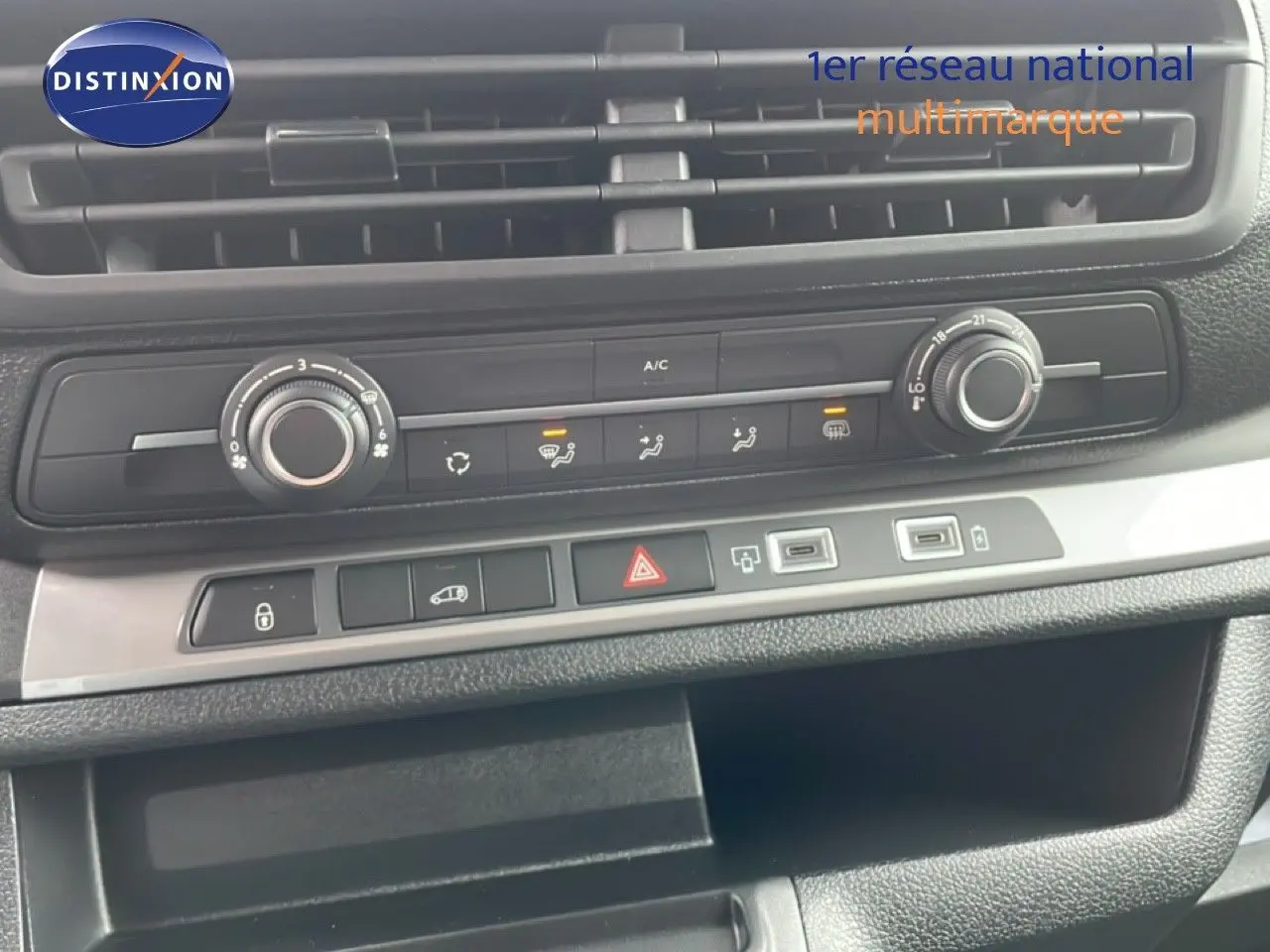 Détail du tableau de bord du Citroën Jumpy gris, montrant les commandes de climatisation et les ports USB.