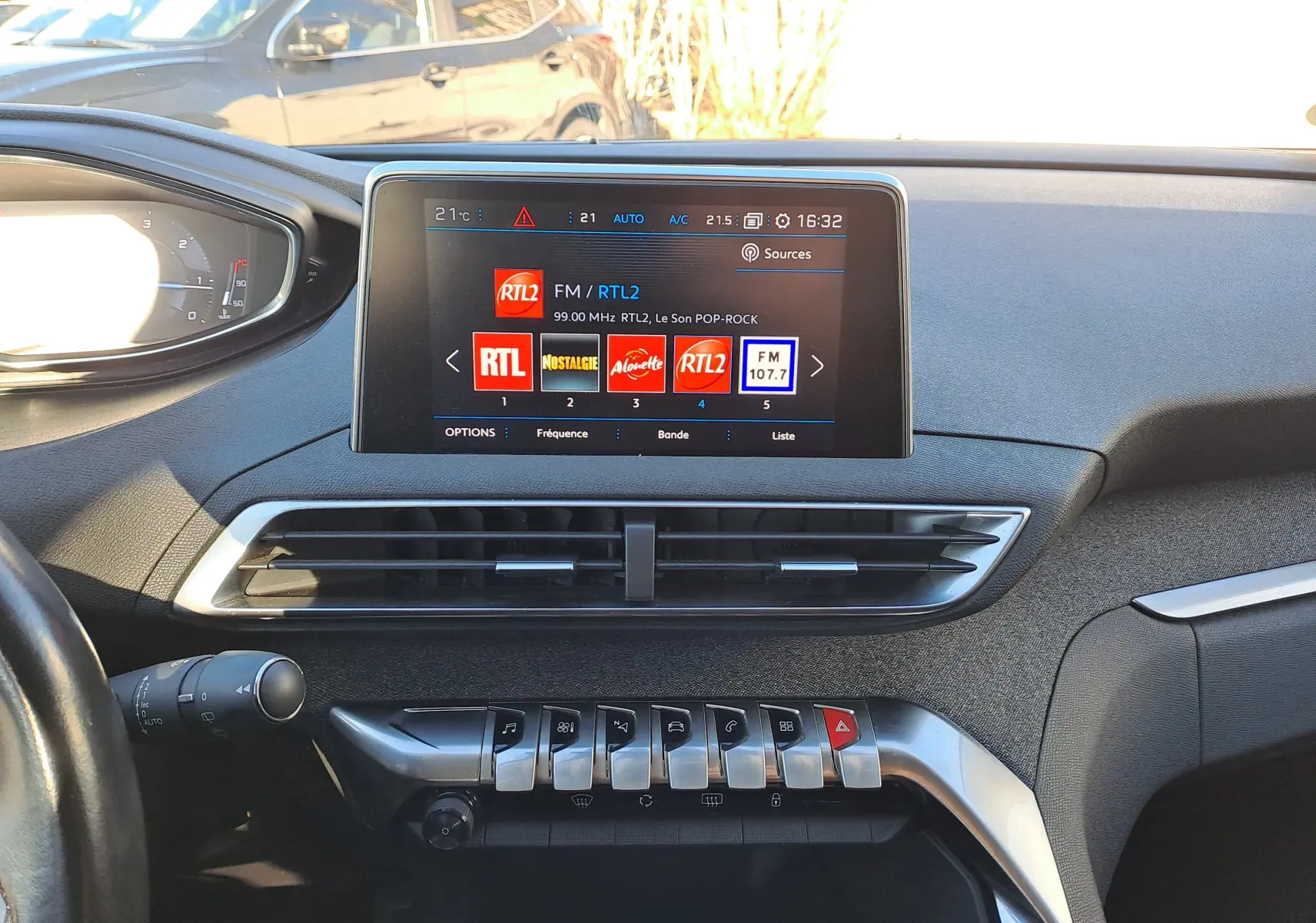 Tableau de bord intérieur du Peugeot 5008 gris, vue frontale centrée sur l’écran tactile et les commandes piano.