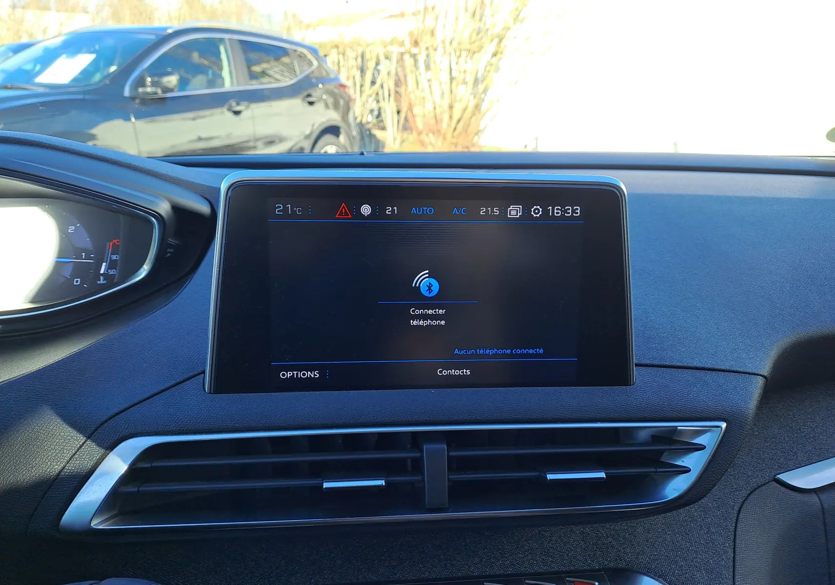 Vue intérieure centrée sur l'écran tactile du tableau de bord du Peugeot 5008 gris, affichant la connexion Bluetooth.
