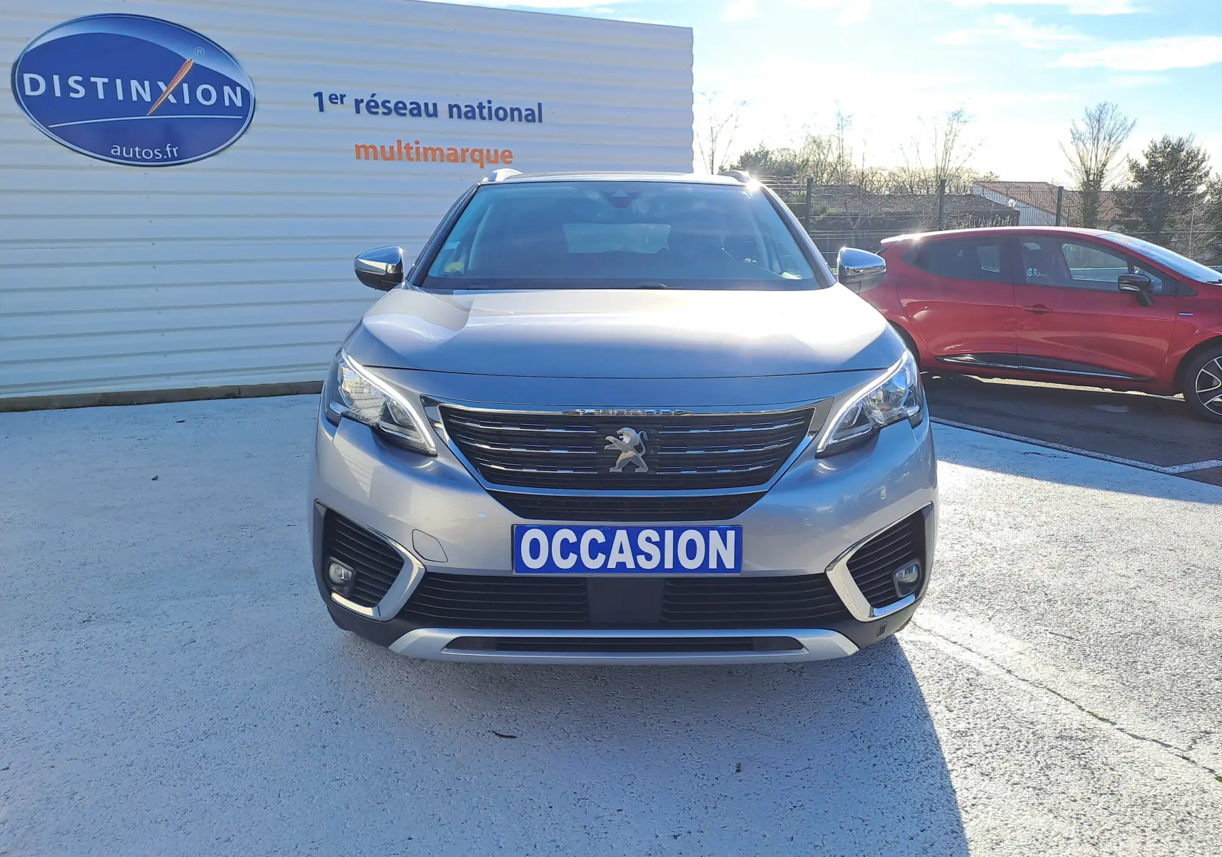 Vue frontale d'un Peugeot 5008 gris 2019 avec plaque "OCCASION" sur un parking extérieur.