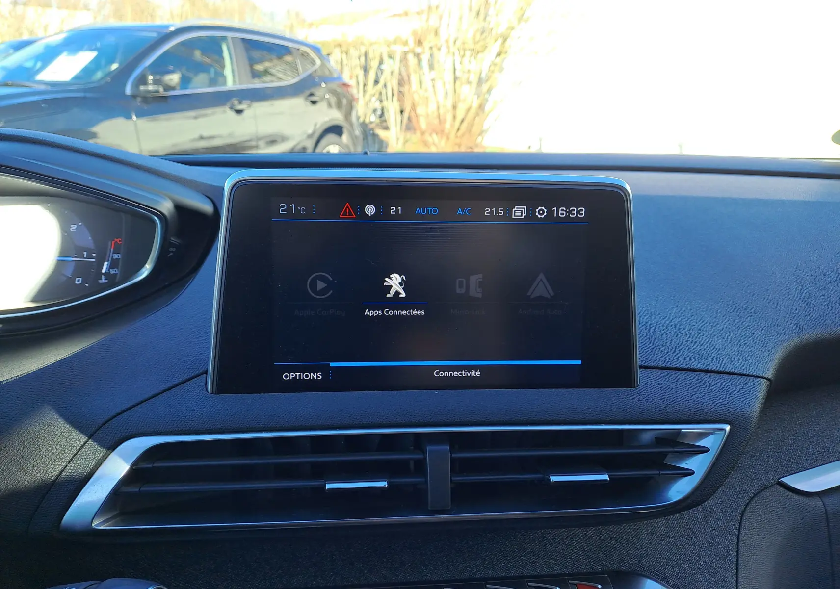 Vue rapprochée de l’écran central tactile du tableau de bord du Peugeot 5008 gris, affichant les applications connectées.