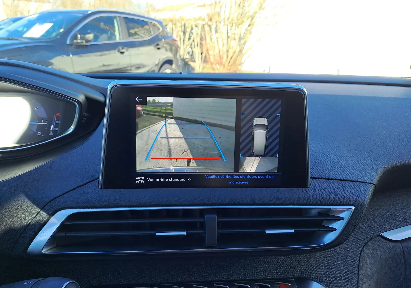 Vue intérieure du tableau de bord du Peugeot 5008 gris de 2019, écran affichant la caméra de recul avec guidage.