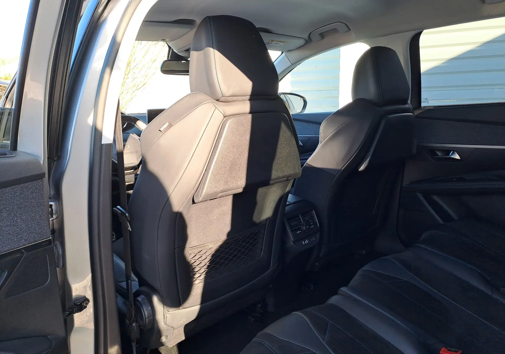 Vue intérieure arrière côté gauche du Peugeot 5008 gris 2019, montrant les sièges en cuir et les aérateurs arrière.
