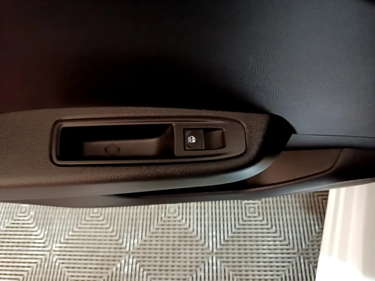 Détail de la commande de verrouillage sur la portière intérieure côté conducteur d’une Renault Clio blanche 2023.