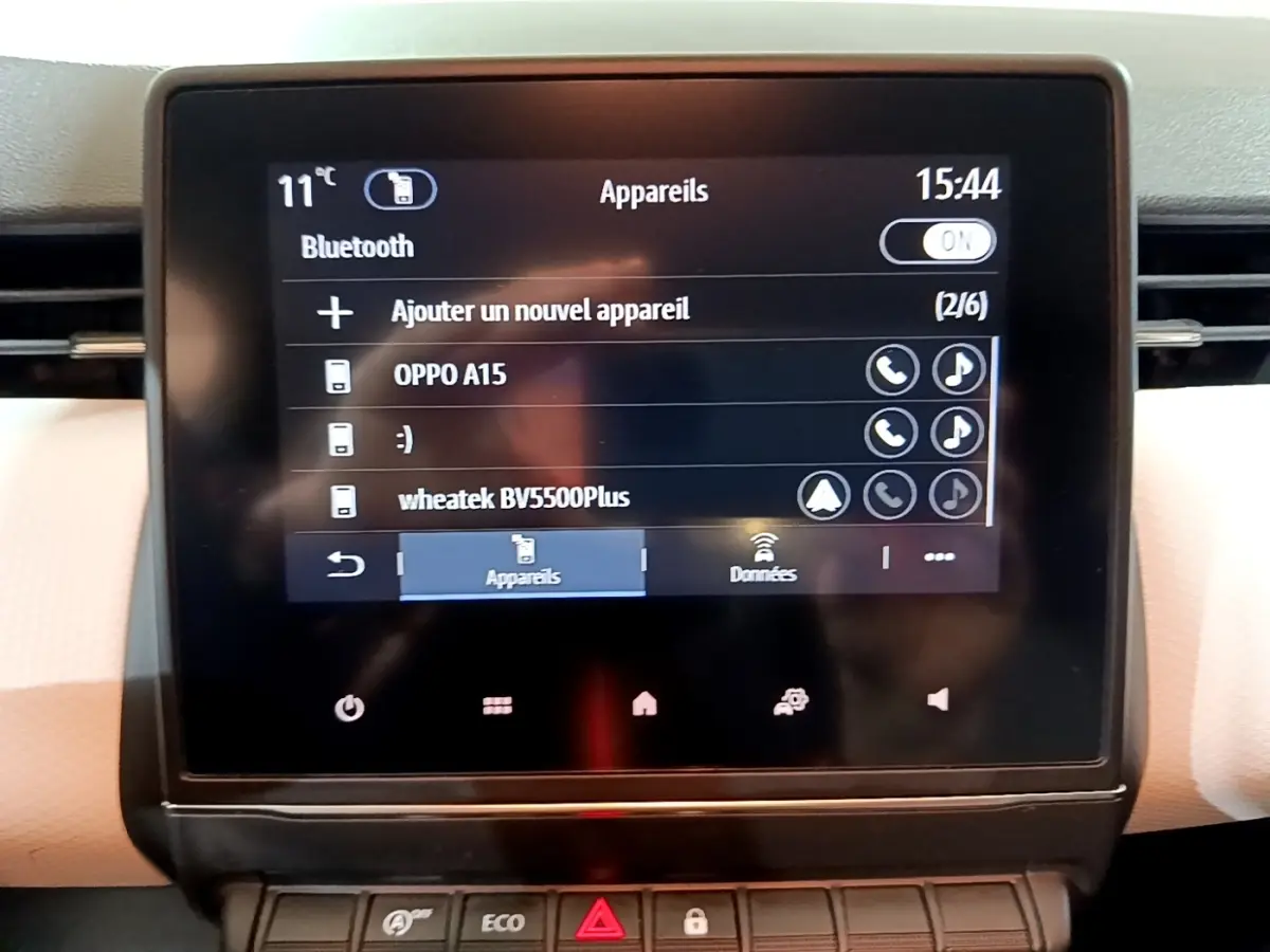 Écran tactile central de la Renault Clio Business blanc, affichant le menu Bluetooth avec plusieurs appareils connectés.