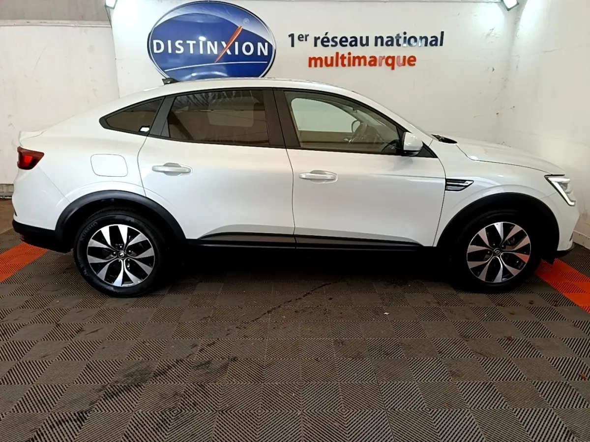 Profil droit d'un Renault Arkana blanc 2023 avec jantes alliage et poignées de porte couleur carrosserie.