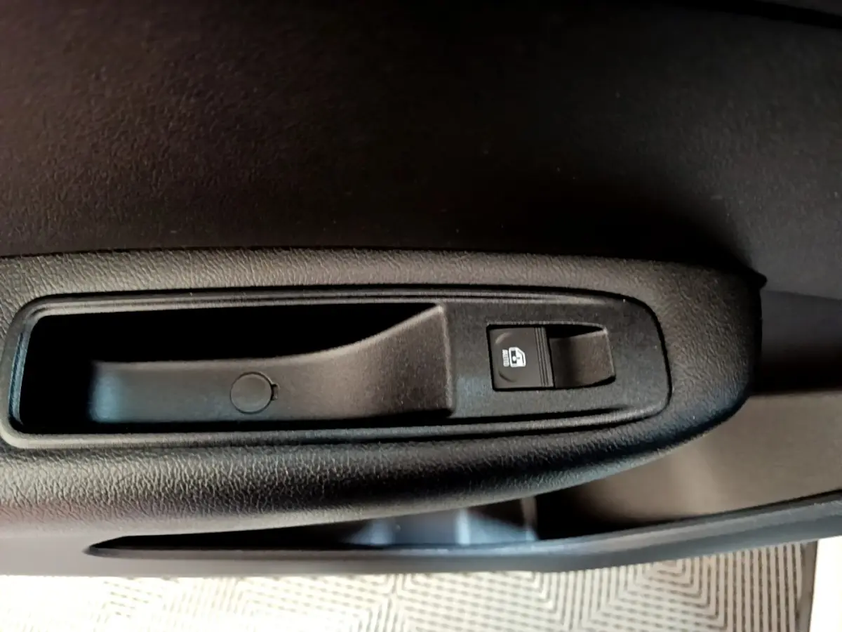 Gros plan sur la poignée intérieure de porte noire avec bouton de verrouillage, Renault Arkana blanc 2023.