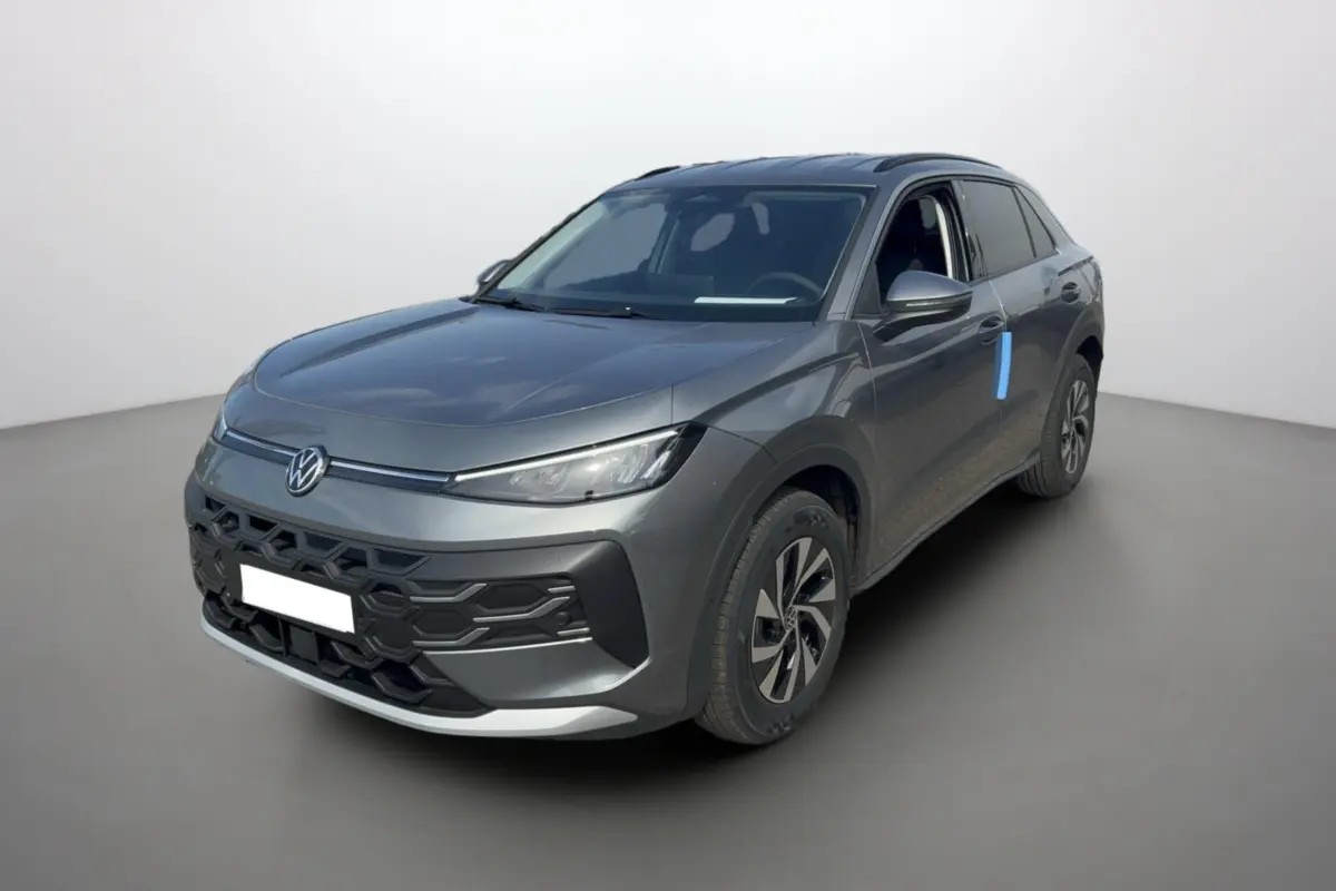 Volkswagen T-Roc gris loup en 3/4 avant droit, avec calandre noire et jantes alu bicolores visibles.