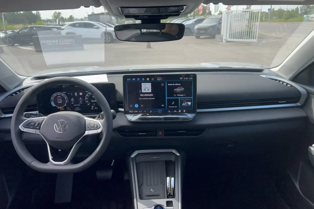 Vue intérieure frontale du tableau de bord du Volkswagen T-Roc gris loup 2026 avec écran tactile central et volant multifonctions cuir.