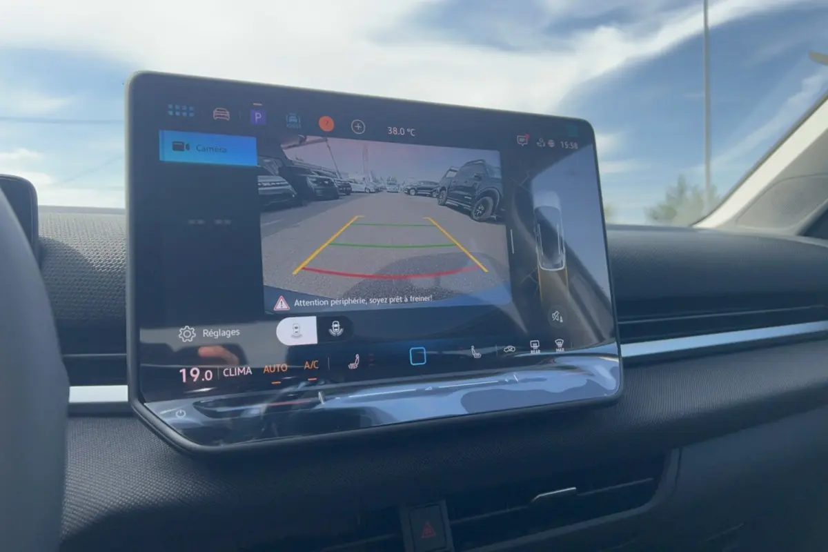 Écran tactile intérieur du Volkswagen T-Roc 2026 montrant la caméra de recul avec affichage des lignes d'aide au stationnement.