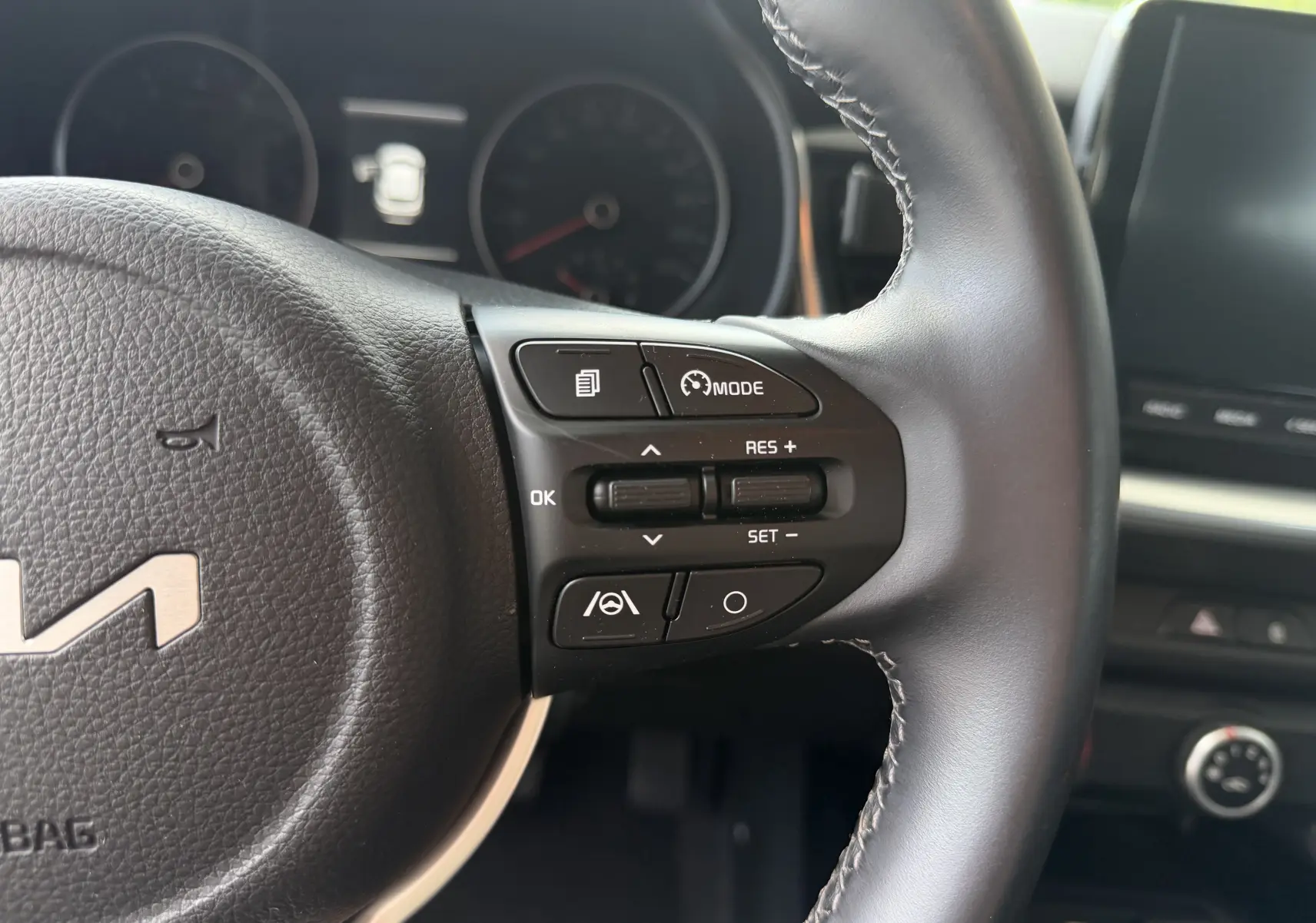 Gros plan sur le volant noir de la Kia Stonic 2022, montrant les commandes de régulateur de vitesse côté droit.