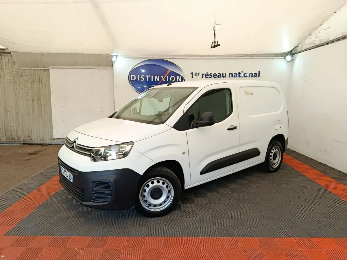 Citroën Berlingo blanc en vue 3/4 avant droit, avec pare-chocs noir et jantes acier simples.