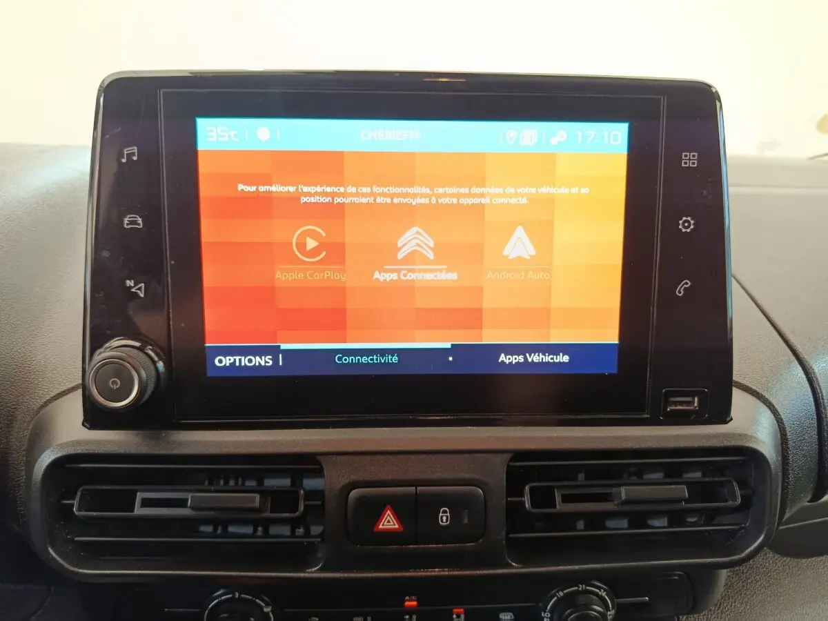 Écran tactile central allumé avec interface Apple CarPlay et Android Auto dans le tableau de bord d'un Citroën Berlingo blanc.