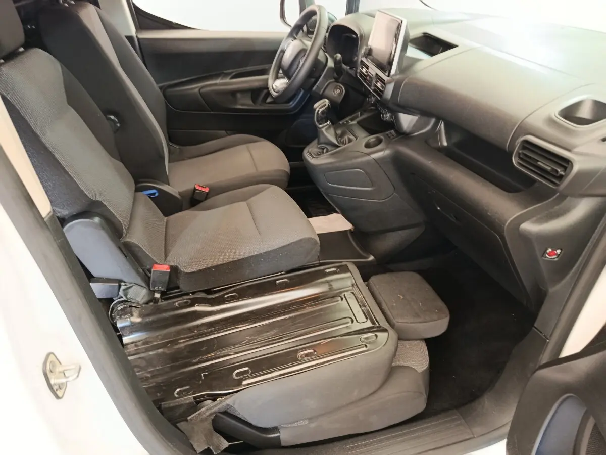 Vue intérieure côté conducteur du Citroën Berlingo blanc 2020, montrant sièges avant et tableau de bord noir.
