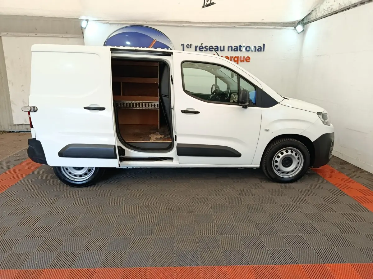 Vue de profil droit d'un utilitaire Citroën Berlingo blanc 2020 avec porte latérale coulissante ouverte montrant l'intérieur de chargement.
