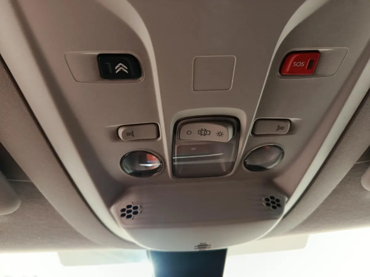 Vue en gros plan du plafonnier beige avec commandes d’éclairage et bouton SOS du Citroën Berlingo blanc 2020.