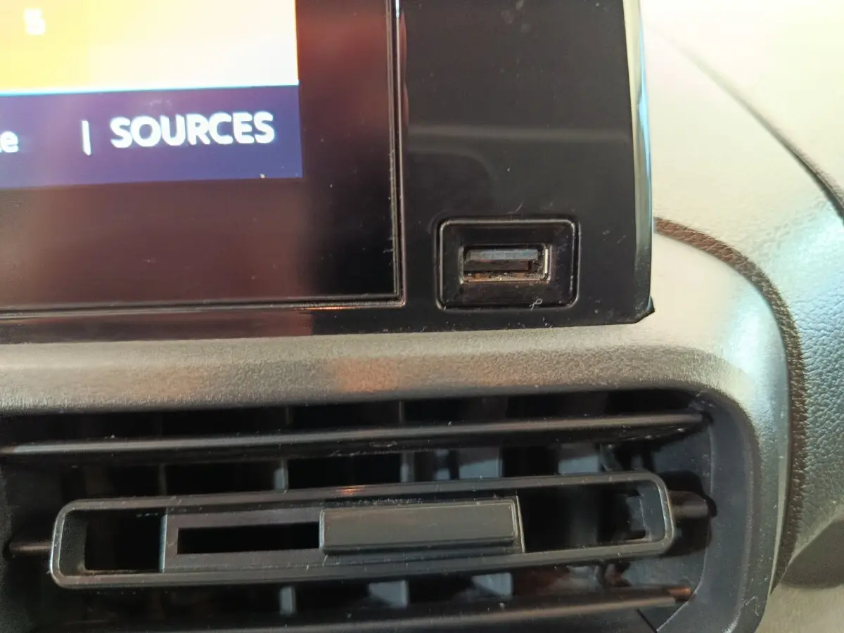 Gros plan sur la prise USB et la grille d’aération du tableau de bord central du Citroën Berlingo blanc de 2020.