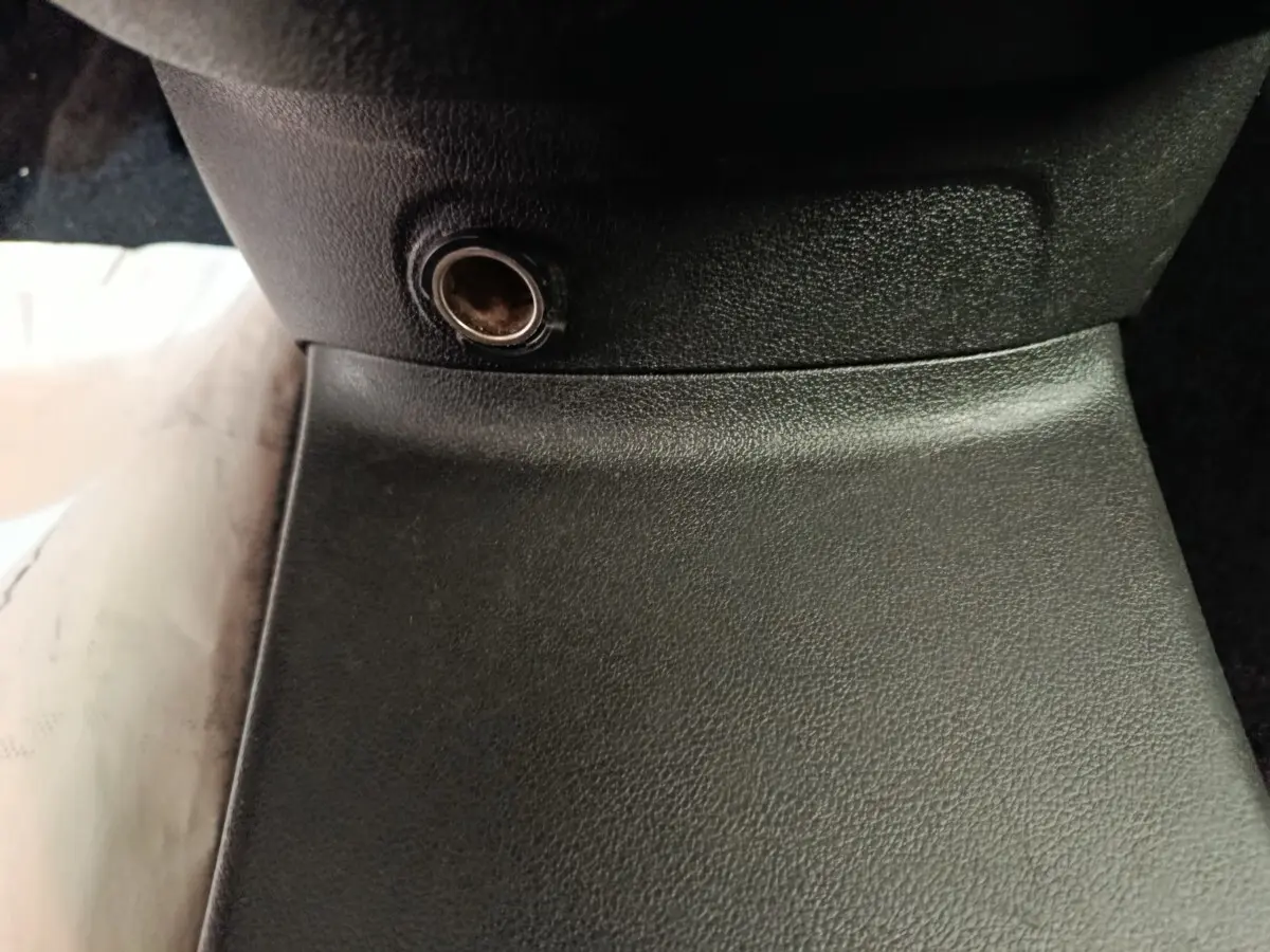 Prise 12V noire en gros plan sur la console centrale intérieure du Citroën Berlingo blanc de 2020.