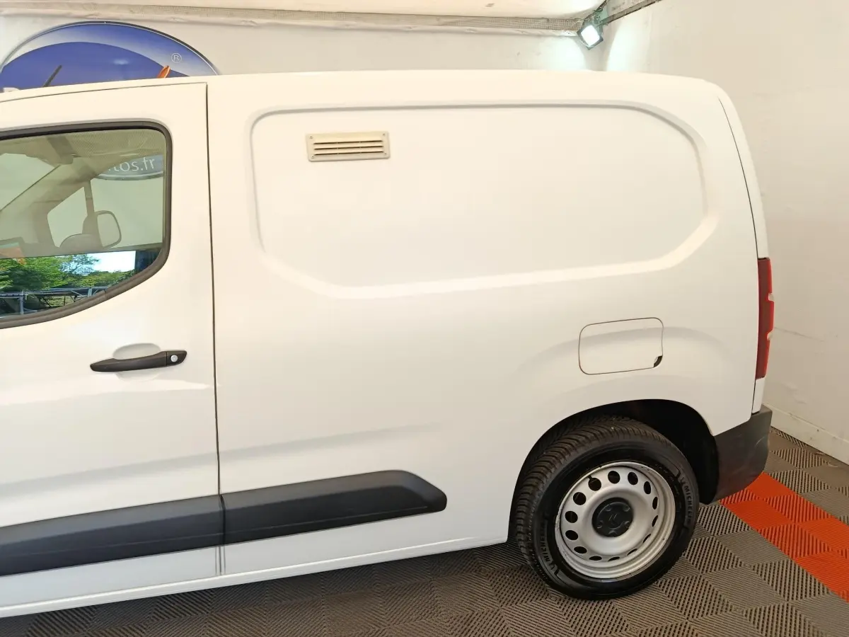 Vue latérale droite d’un utilitaire Citroën Berlingo blanc avec porte latérale pleine et jante acier.