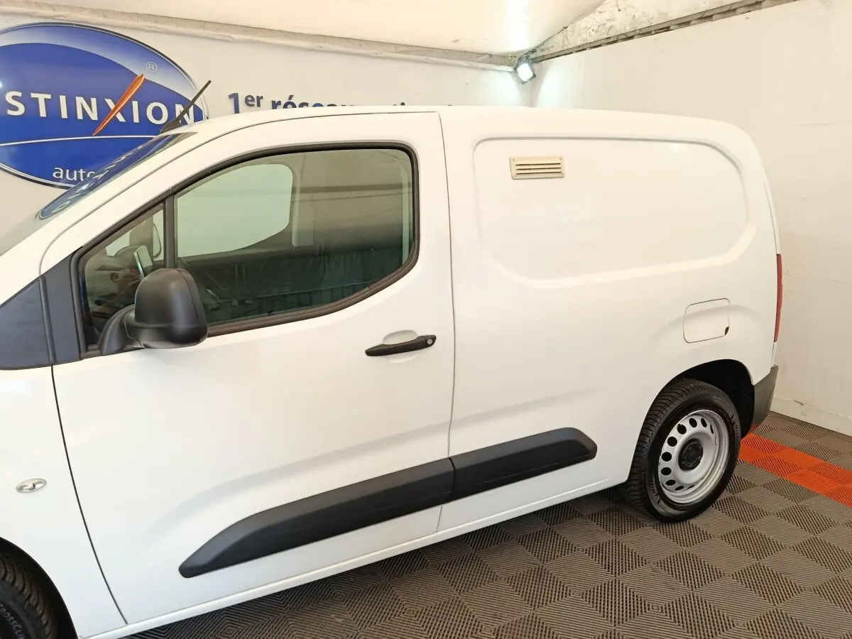 Vue de profil côté gauche d’un Citroën Berlingo blanc utilitaire avec porte latérale pleine et jantes acier.