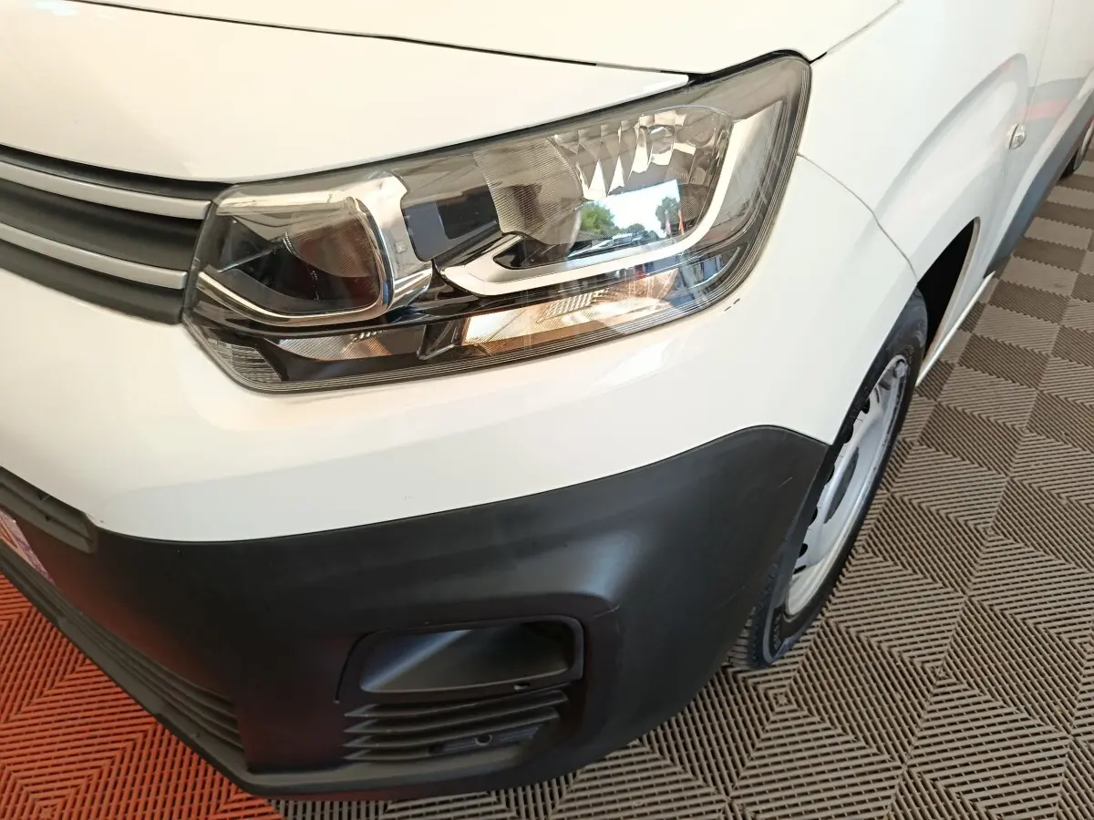 Gros plan sur l'avant droit blanc du Citroën Berlingo 2020, mettant en valeur le phare et le pare-chocs noir.