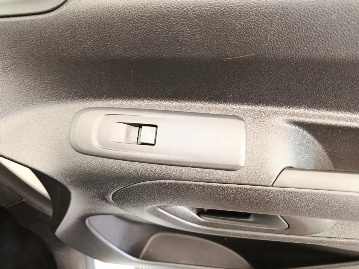 Gros plan sur la poignée de porte intérieure noire du Citroën Berlingo blanc, version M 1000kg BlueHDi 2020.