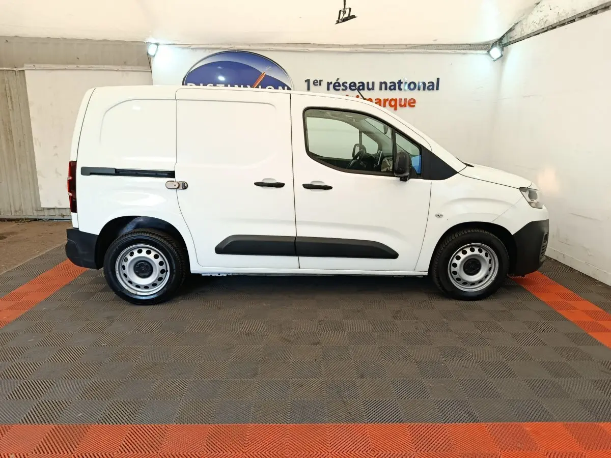 Vue de profil côté droit d’un utilitaire Citroën Berlingo blanc, avec porte latérale coulissante et jantes acier.