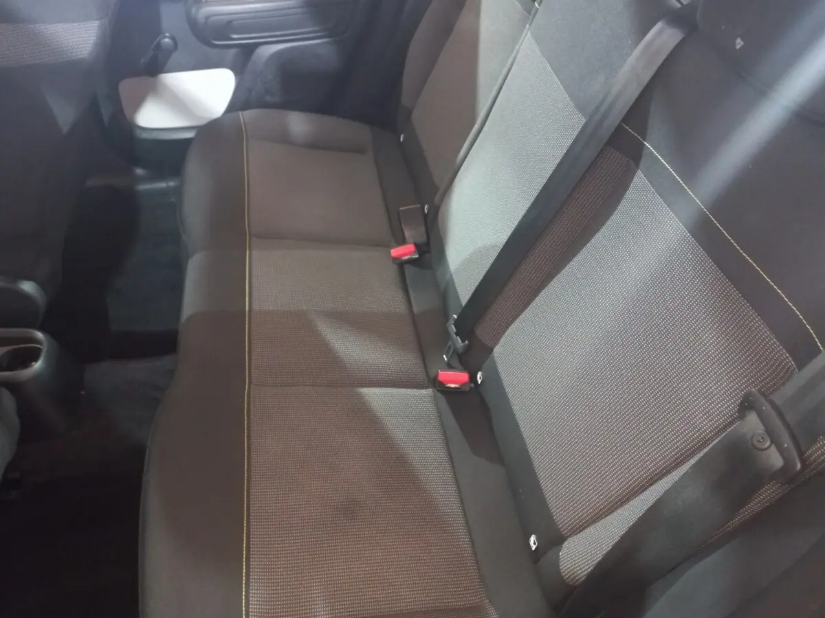 Vue intérieure du siège arrière droit de la Citroën C3 2024 noir avec ceinture de sécurité et tissu gris à motifs.
