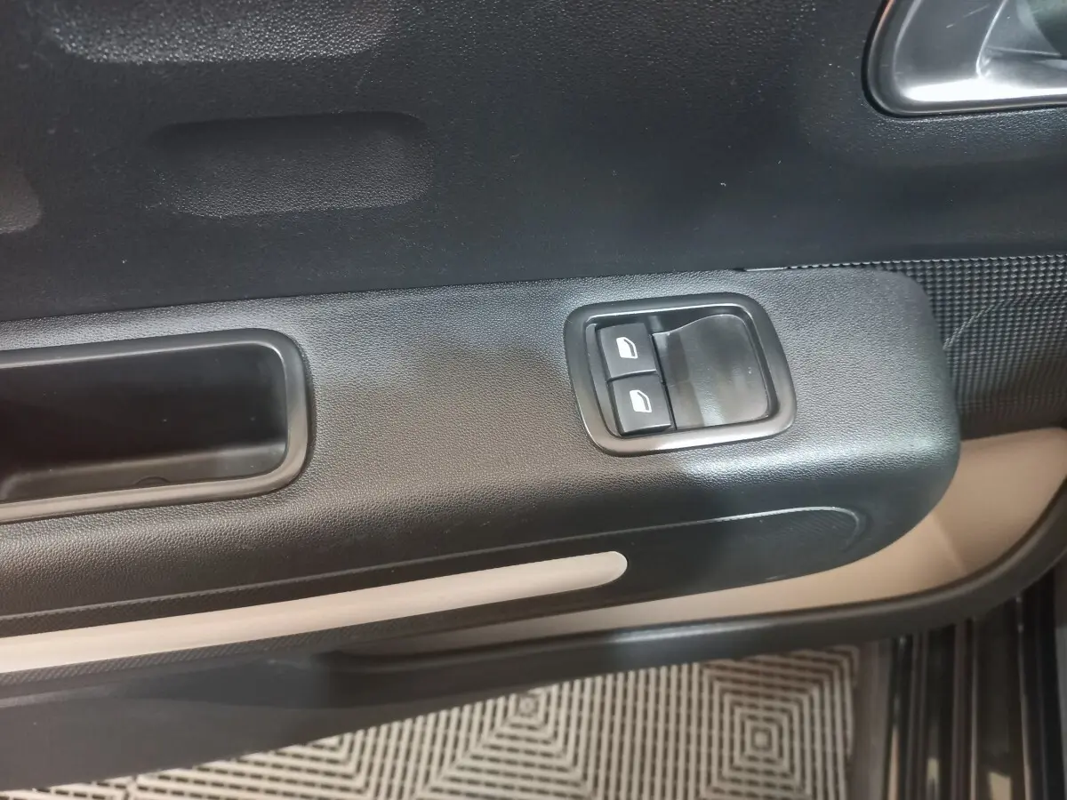 Détail de la porte côté conducteur de la Citroën C3 noire 2024, avec commandes des vitres électriques et poignée intégrée.
