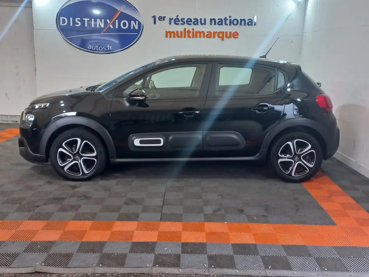 Profil côté gauche d'une Citroën C3 noire 2024 avec protections latérales et jantes distinctives en concession.
