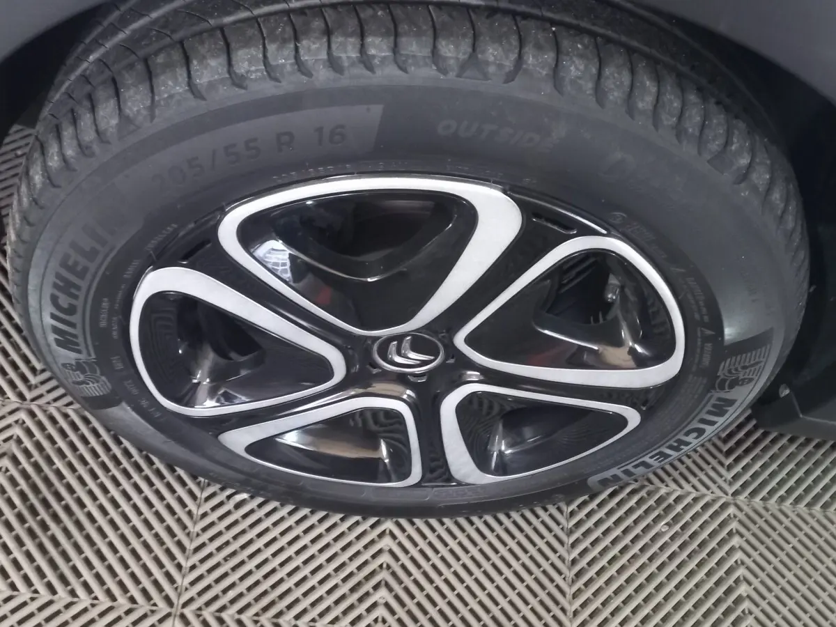 Gros plan sur la roue avant gauche d'une Citroën C3 noire, jante alliage noire et argent avec pneu Michelin.