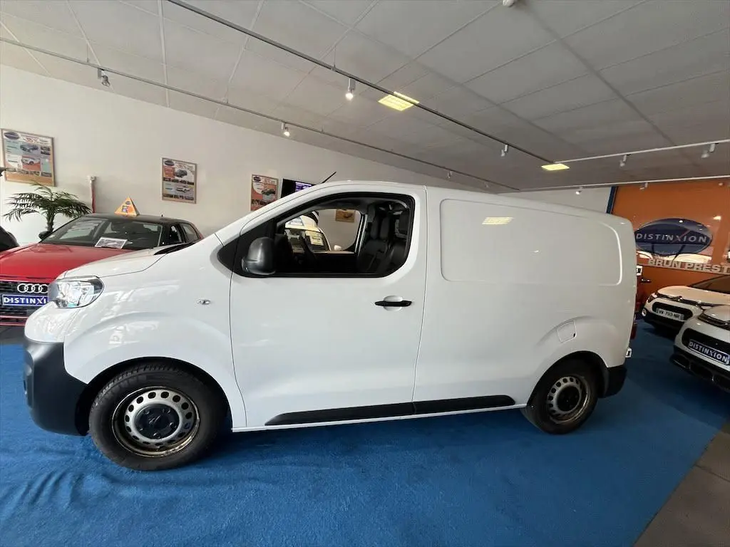 Peugeot Expert Fourgon blanc en vue profil côté gauche, intérieur visible par la porte ouverte en concession.