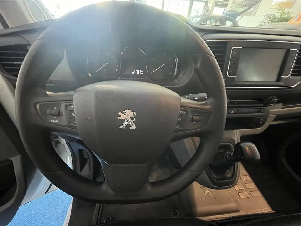Vue intérieure centrée sur le volant Peugeot noir et le tableau de bord du fourgon blanc Expert 2019.