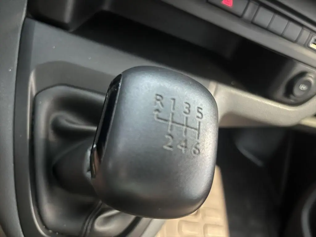Gros plan sur le levier de vitesses manuel noir du Peugeot Expert Fourgon blanc, montrant les six rapports et la marche arrière.