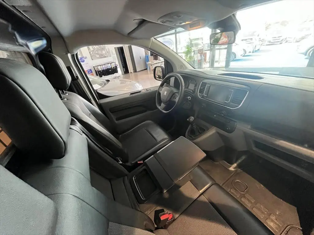 Intérieur noir du Peugeot Expert Fourgon 2019, vue côté conducteur avec tableau de bord et banquette avant modulable.