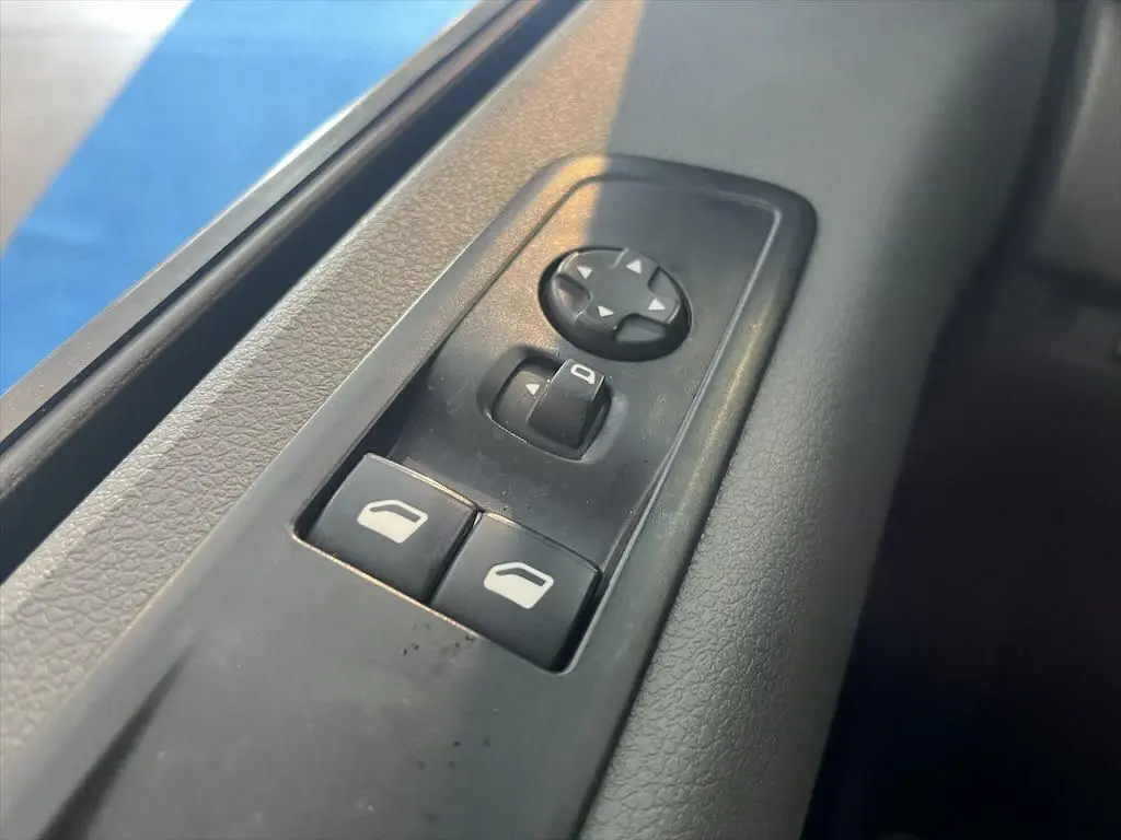 Gros plan sur les commandes de réglage des rétroviseurs et des vitres côté conducteur du Peugeot Expert Fourgon blanc.