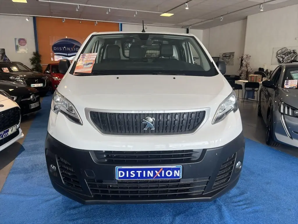 Vue frontale d'un Peugeot Expert Fourgon blanc avec calandre noire et plaque Distinxion en concession.
