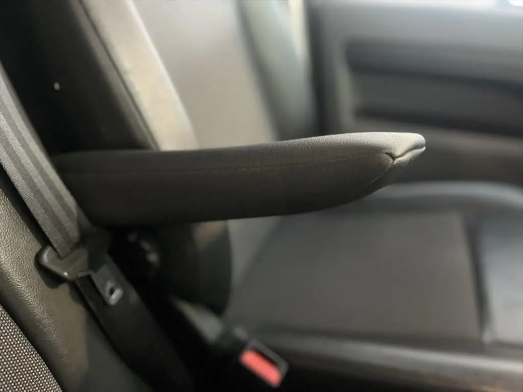 Accoudoir en tissu noir du siège avant gauche du Peugeot Expert Fourgon blanc, vue rapprochée intérieure.