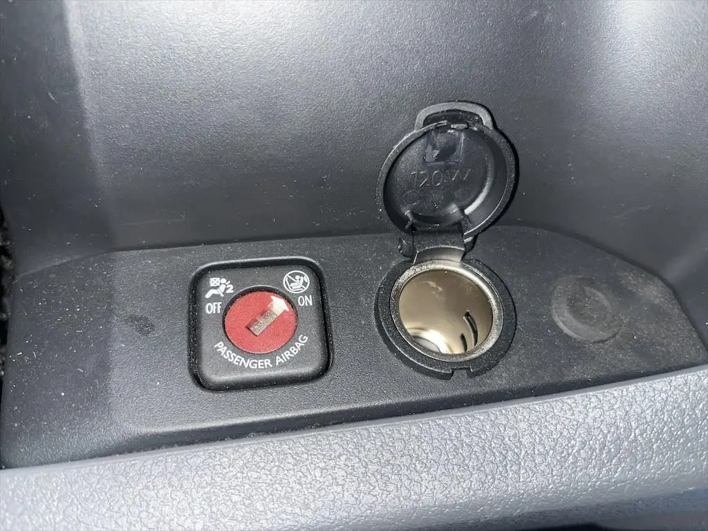 Gros plan sur l'interrupteur d'airbag passager et prise 12V dans l'habitacle du Peugeot Expert Fourgon blanc.